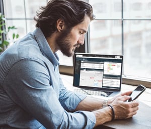 Man-working-on-phone-and-computer-using-1CRm